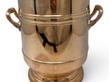 a large brass ice bucket with handles on a white background