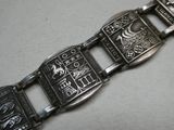 un bracelet en argent orné d'un motif, posé sur une table
