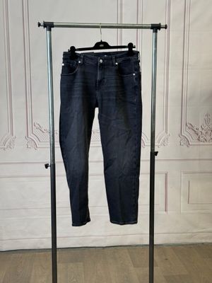 a pair of jeans hanging on a clothes rack in a room