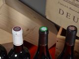 several bottles of wine are lined up in a wooden box