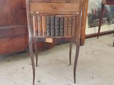 une petite table sur laquelle est posé un livre, devant une armoire