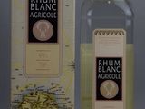 une bouteille de rhum blanc Agroulle à côté d'une carte du monde