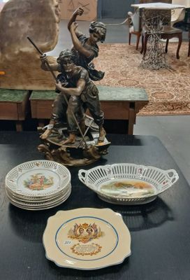 de nombreuses assiettes et bols posés sur une table, avec une statue en arrière-plan