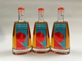 three bottles of vinegar are lined up on a white surface