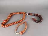 collier composé de perles en bois avec un fermoir en argent sur fond gris
