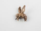 a close up of a metal insect on a white surface
