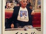 a polaroid picture of a man sitting at a table in a diner