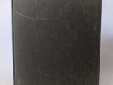 an old book sitting on top of a white table next to a white wall
