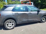 a grey car that is parked on the side of the road