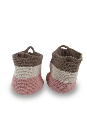 pair of pink and white crocheted baby booties on a white background