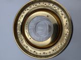 a close up view of a brass plate with a glass in the center