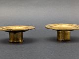 pair of antique brass candlesticks on a grey background