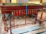 un lit en bois sur lequel est inscrit quelque chose, au milieu d'une pièce
