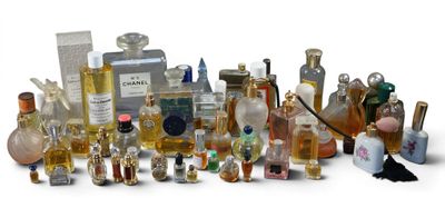 many different bottles of perfume on a white surface