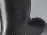 a black sculpture of a man ' s hand with a ring on it ' s finger