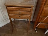 a small table with a drawer on it in the corner of a room