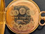 a gold pocket watch with a picture of horses on it