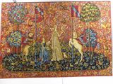 the tapestry is hanging on the wall of a room with a picture of a woman and two dogs
