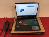 dell laptop with power cord and charger sitting on a red table