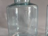 two glass jars sitting on a table with a tag on them