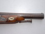 a close up of a gun on a white surface with a wooden handle