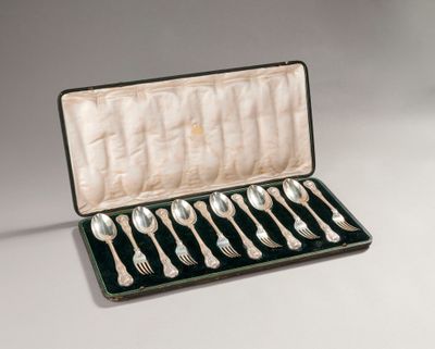 six silver spoons in a case on a table
