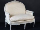 une chaise blanche de style ancien, avec un dossier et des accoudoirs rembourrés de blanc