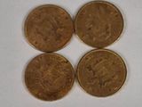 four coins are arranged in a row on a white surface