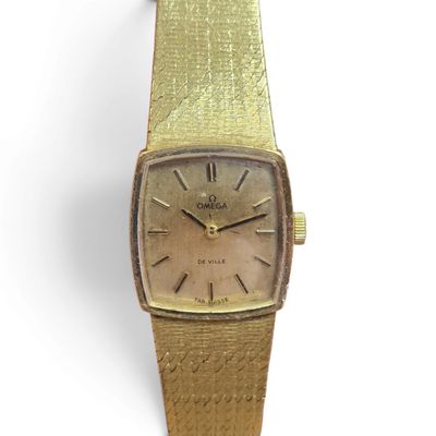 an old gold wrist watch with roman numerals and roman numerals