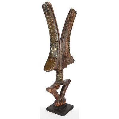 a wooden sculpture of two horns on a black base