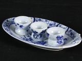 a blue and white plate with three cups and saucers on it