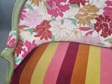 a colorful striped couch with a colorful pillow on top of it