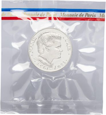 a coin in a plastic bag with a red, white and blue ribbon