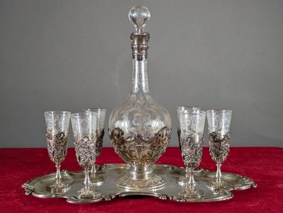 un plateau en argent sur lequel sont posés des verres à vin et une carafe