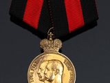 a close up of a medal with a red ribbon around it