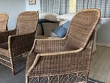 two wicker chairs in the living room of a house