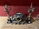 une horloge posée sur une table à côté de quelques bougies
