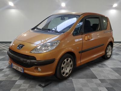 une photo d'une petite voiture orange garée dans un garage