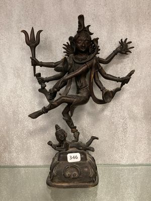statue en bronze du dieu hindou Shiva, assis sur un rocher et tenant un bâton