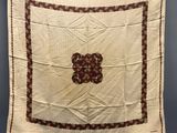 a white and red quilt hanging on a clothes line