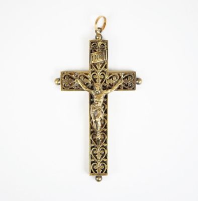 une croix dorée sur laquelle est représenté un crucifix, sur fond blanc