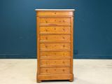an old wooden chest of drawers against a blue wall