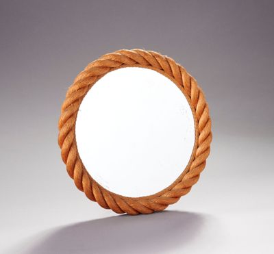 un miroir rond entouré d'une corde, posé sur une table