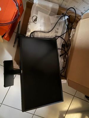 un écran d'ordinateur posé par terre à côté d'un carton