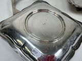a silver plate with a handle on a white table