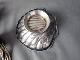 a silver plate with a silver candle holder on a table