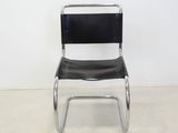 a black chair that is sitting in the corner of a room