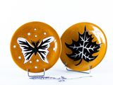 deux assiettes jaunes ornées de motifs en noir et blanc