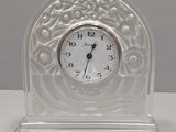 a glass clock with a white face on a table
