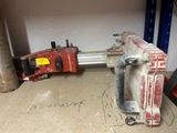 a clamp that is sitting on the floor next to a pipe cutter